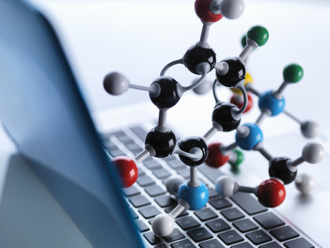 Molecular model sitting on top of lap top computer keyboard to illustrate science education and computer aided research