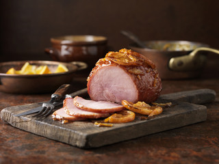 Christmas dinner. Small roasted orange marmalade gammon on chopping board