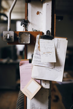 Still life of clipboard and notes on pillar in pipe organ workshop