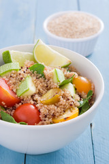 Quinoa, zucchini, tomatoes and spinach on blue wooden table
