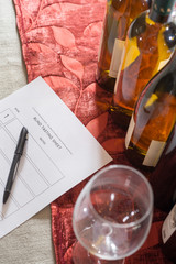 Row of Wine Bottles with Glasses and a Tasting Form