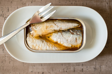 Fork on Opened Can of Sardines in Dinner Plate