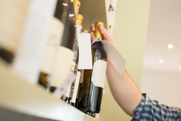 Bottle of Wine Taken Off a Shelf by a Person