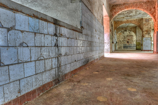 Dirty, empty enclosed space in a derelict prison.