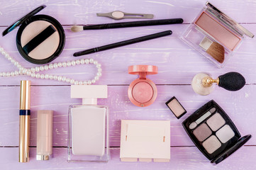 Naklejka premium Colorful cosmetics on pastel wooden workplace. Top view