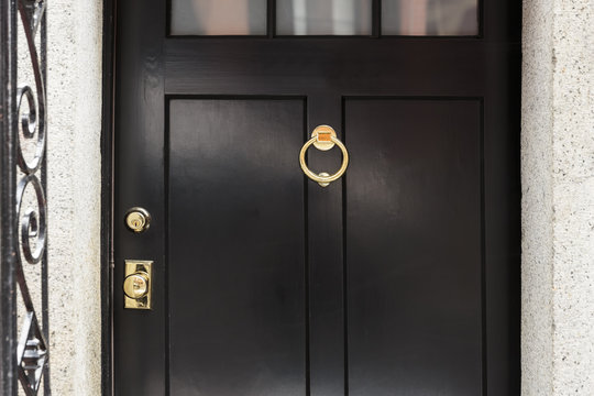 Black front door, close up with brass door knocker