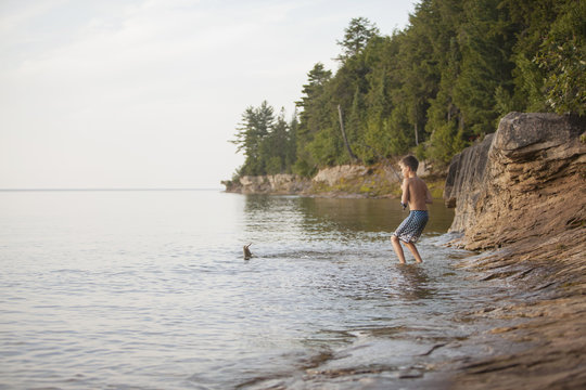 Teenage boy catching fish in Lake Superior, Au Train Bay, Michigan, USA