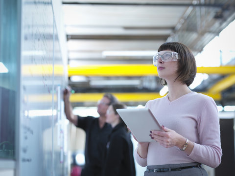 Female worker using digital tablet in factory