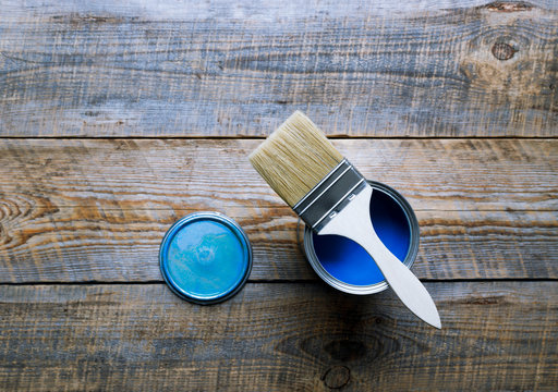 painting at home with can blue paint on wooden background