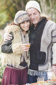 Portrait of mature hippy couple drinking cider in garden