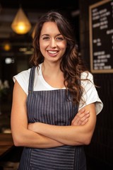 Portrait of smiling barista with arms crossed