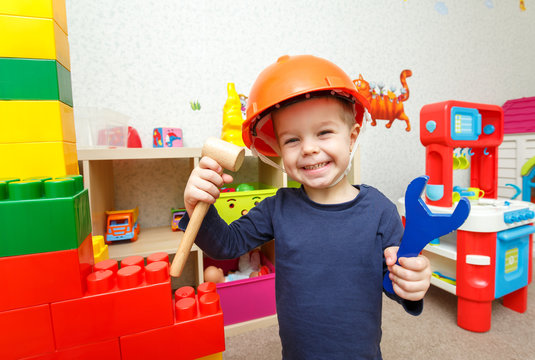 Funny little repairman with toy hammer and wrench in daycare