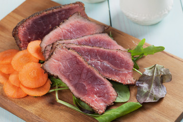Rare beef steak with carrot and green salad