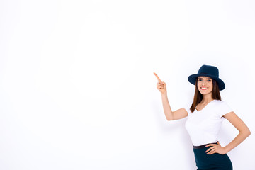 Just look at that! Beautiful young woman pointing up and smiling while standing against white background