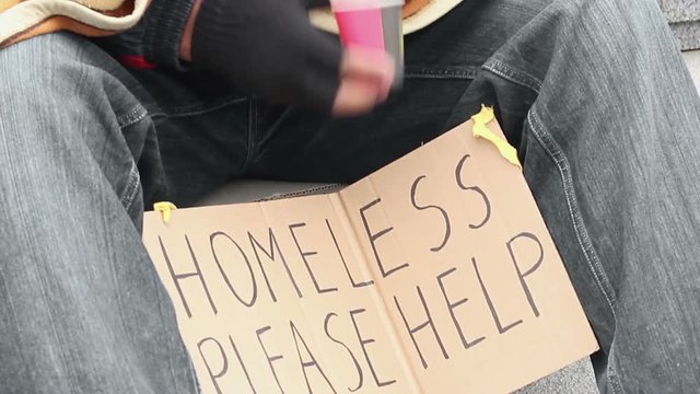 Frozen homeless man covered with blanket, begging money, holding paper cup