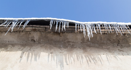 icicles on a roof of a house in winter