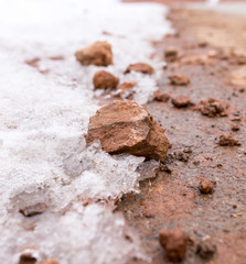 snow on red clay in nature