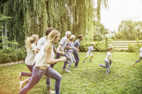 Three generational family running in garden