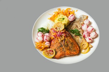 Roasted trout with vegetable and rice, isolated on gray background