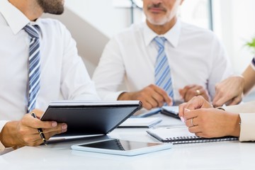 Mid section of businessmen and businesswomen discussing