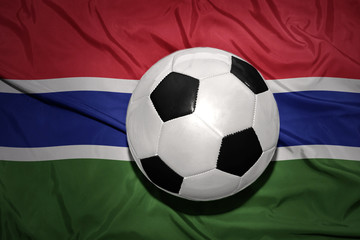 Fototapeta premium black and white football ball on the national flag of gambia