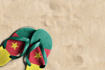Thongs with flag of Cameroon, on beach sand