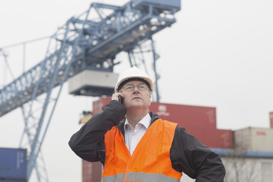 Dock worker using smartphone at port