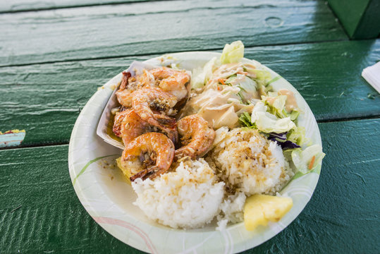 Plate of garlic shrimp and rice on porch, Hawaii, USA