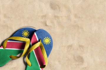Thongs with flag of Namibia, on beach sand