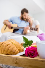 Obraz na płótnie Canvas Croissant and a rose on tray