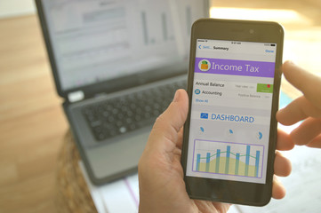 A man using a mobile app to calculate his income tax.