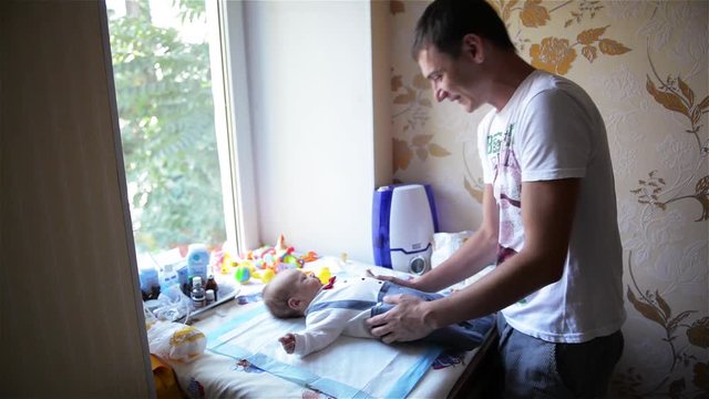 Baby laughing, Young father playing with his baby, Baby lie on swaddle board