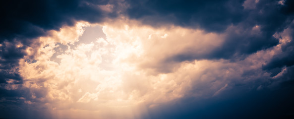 Abstract of sunburst through dark stormy cloud, with tone effect