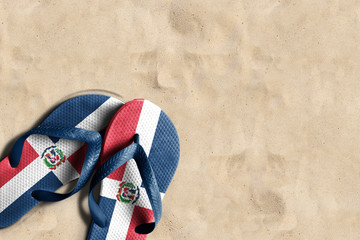 Thongs with flag of Dominican Republic, on beach sand - obrazy, fototapety, plakaty
