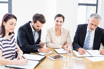 Workers are reading their notes and one is smiling