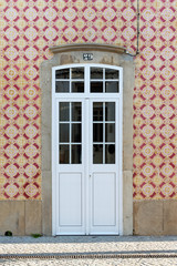 Fototapeta na wymiar Vintage doorway with traditional Portuguese tiles - Azulejos, Portugal