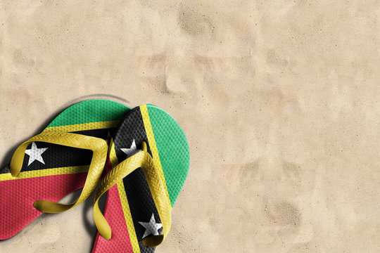 Thongs with flag of Saint Kitts and Nevis, on beach sand
