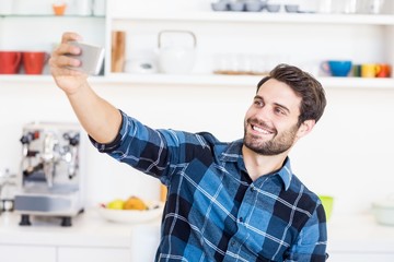 A man is taking a picture of himself with a smartphone