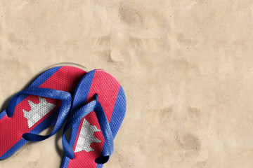 Thongs with flag of Cambodia, on beach sand