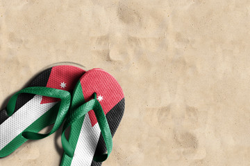 Thongs with flag of Jordan, on beach sand