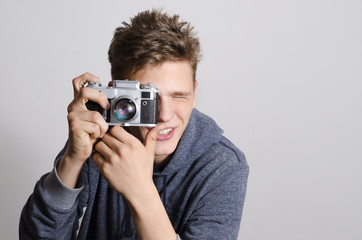Teenager taking picture with old analog camera, photography enthusiast. 