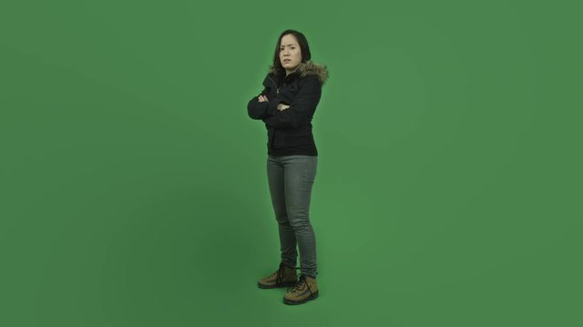 caucasian girl with winter jacket isolated on green screen upset with arms crossed