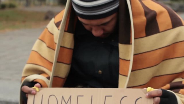 Adult man holding homeless please help sign, poverty, social vulnerability