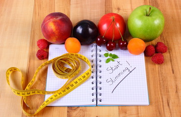 Fruits, vegetables and centimeter with notebook, slimming and healthy food