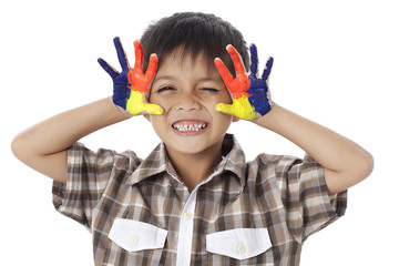 a boy smiling with a paint hand