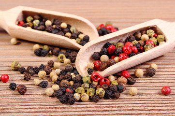 Fresh colored pepper with spoon on wooden background