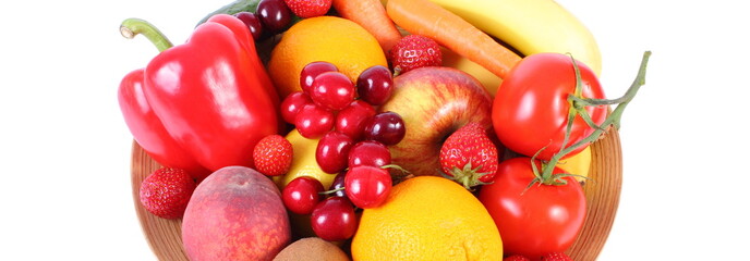 Fresh fruits and vegetables on wooden plate