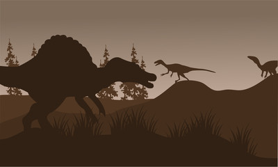 Silhouete of spinosaurus and eoraptor in hills