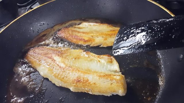 Frying zander or pike-perch fillets, on a frying pan