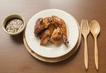 Grill chicken with spicy thai style sauce on wood table